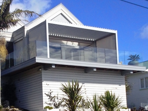 Freestanding Bask Louvre roof on a beautiful beachside home deck for protection for sun wind and rain